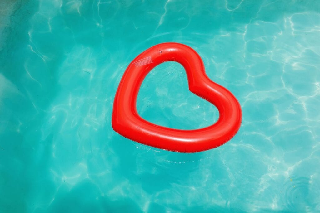 Red heart-shaped pool float in the middle of the pool