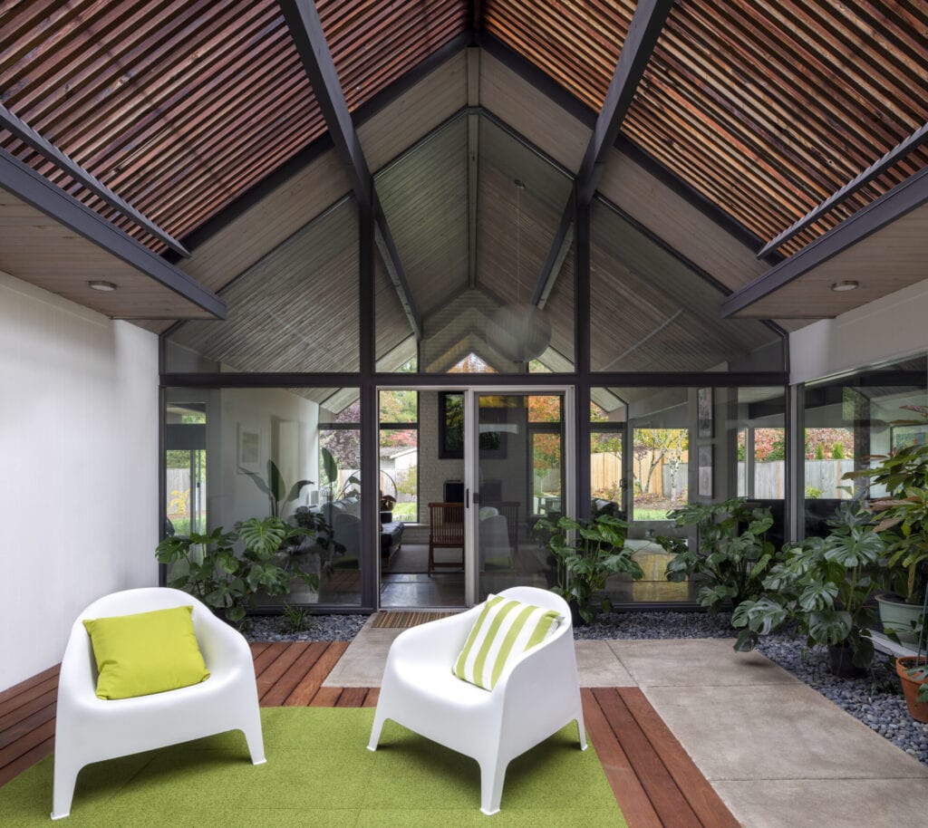 Mid-century modern living space with plants, large windows and a spacious room