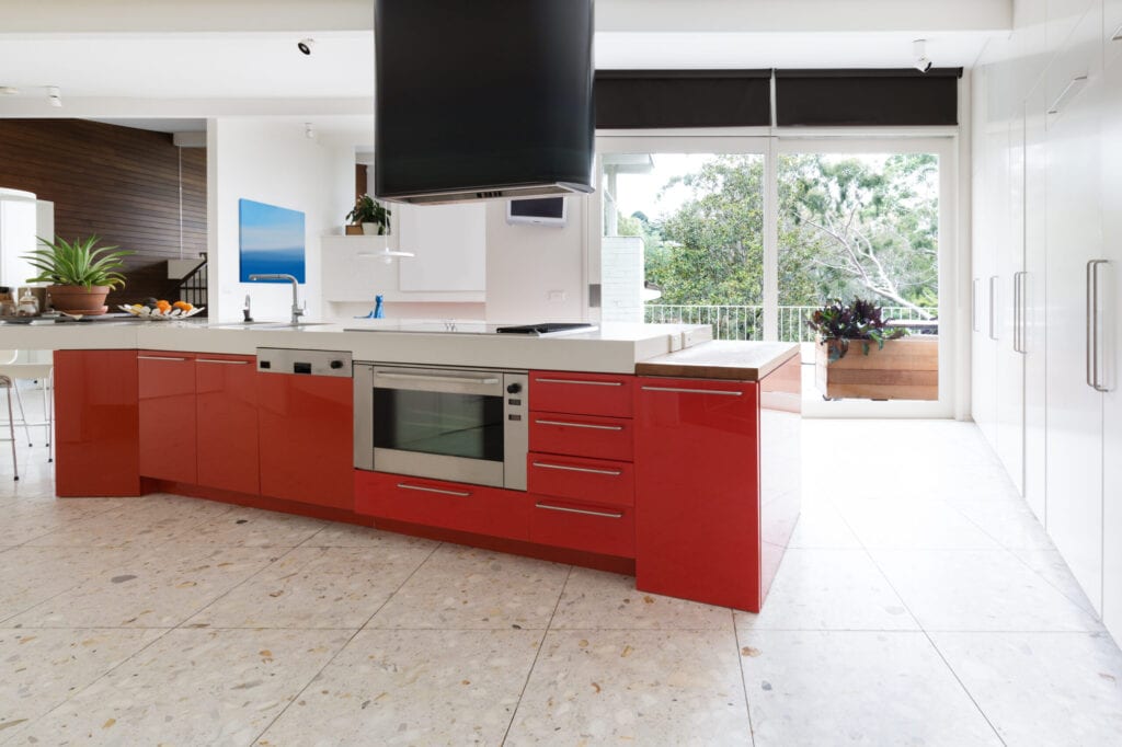 Orange red kitchen cabinets in island bench in modern luxury Australian home