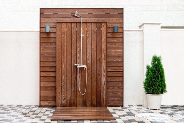 Outdoor shower finished with wood deck paneling