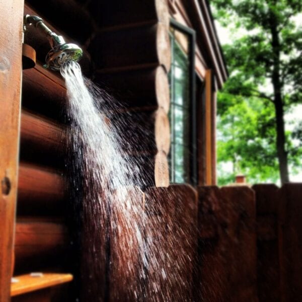 Outdoor shower at log cabin, running shower