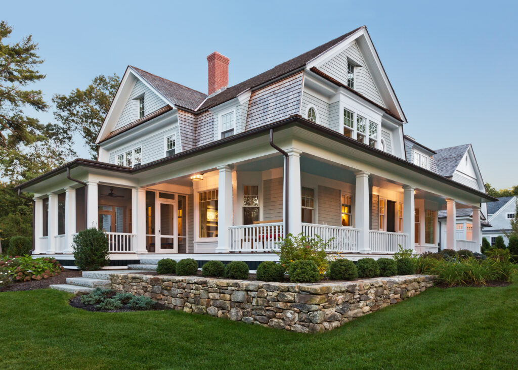 Exterior view of custom built home with exterior lighting and manicured landscaping.