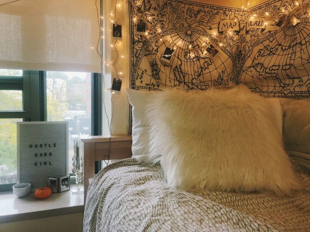 College dorm bed with tapestry on the wall