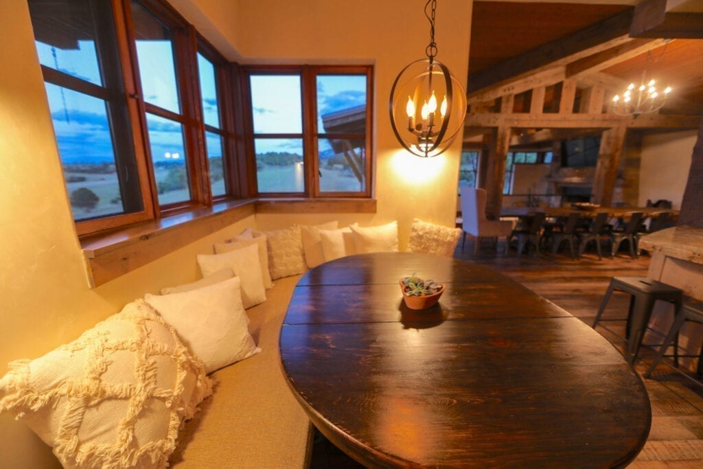 Chandeliers and a breakfast nook that flows into the dining room in the interior of a natural home built with sustainable materials in Carbondale, CO.