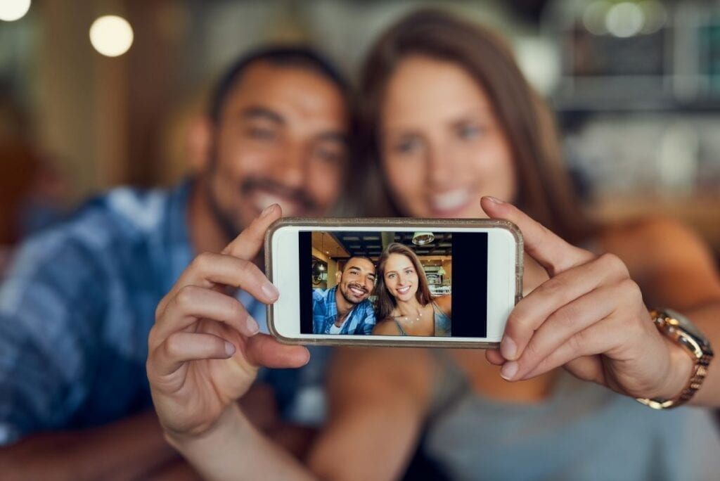 Couple taking a selfie or recording a video on their smartphone
