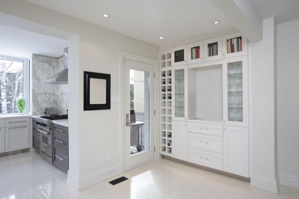 Kitchen with green cabinets and island, built in custom wine shelving