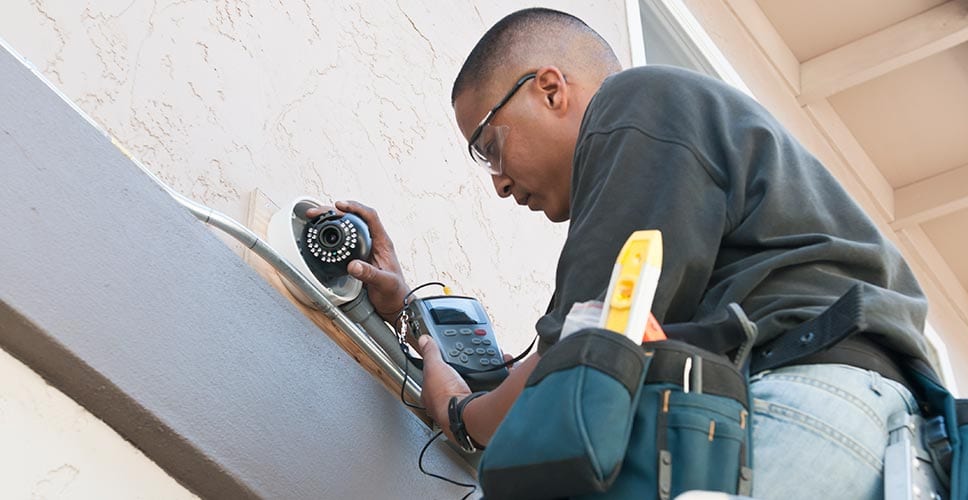 A utility provider checking on outdoor cameras to ensure home safety.