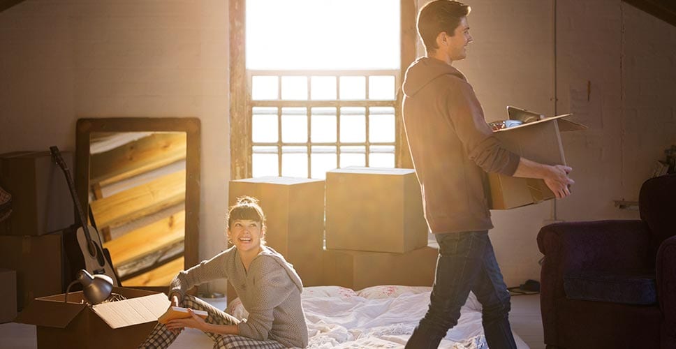 Young couple moves furniture into their new home.