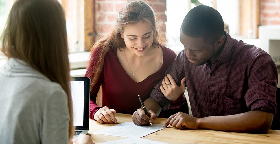 Couple signing lease with apartment agency