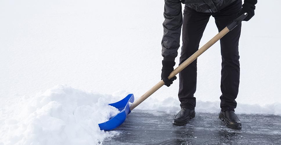 a person outside shoveling snow out of their driveway