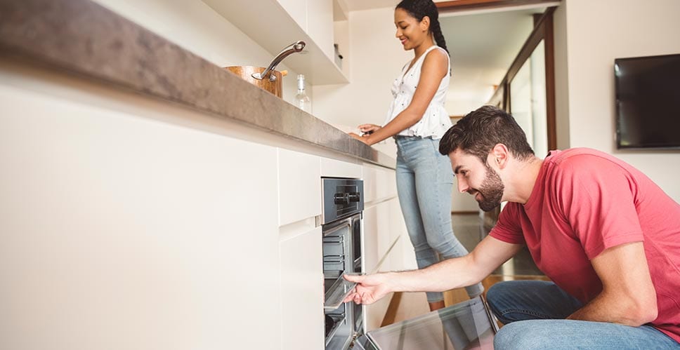 Young couple cooks in their kitchen with few worries about their home appraisal process.