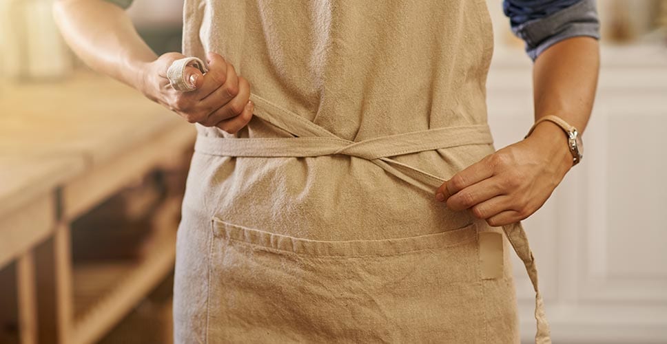 A woman putting on his apron — a product worth investing in for move day.