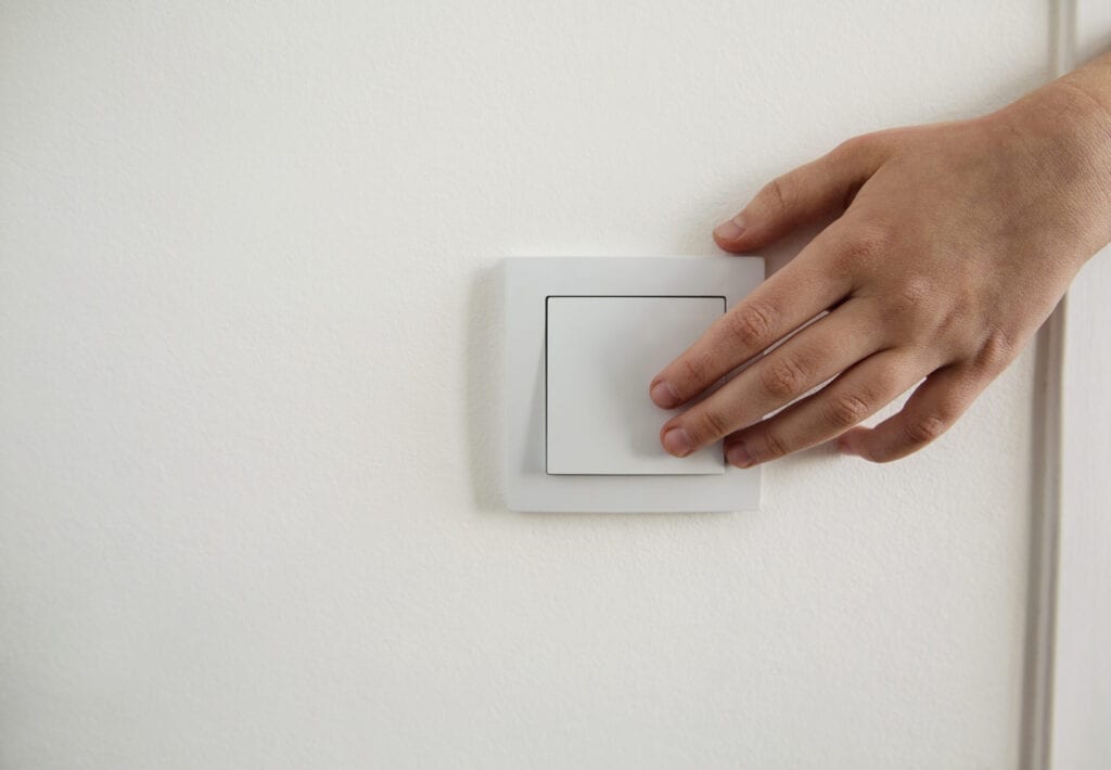 Cropped hand pressing light switch