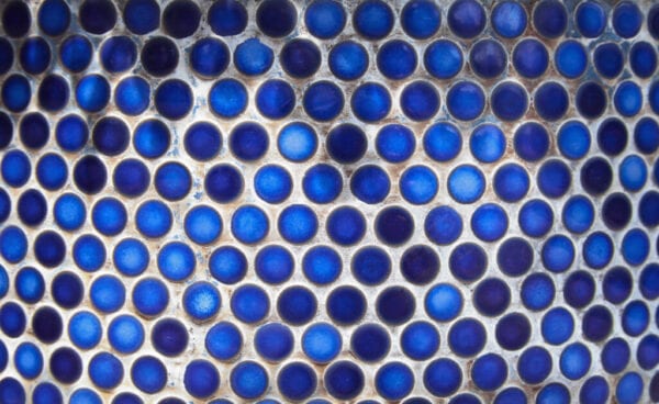 Blue penny circular ceramic tiles background. Tiled bathroom wall