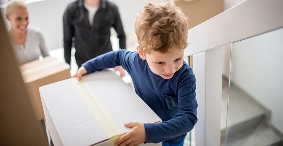 small boy carrying a box