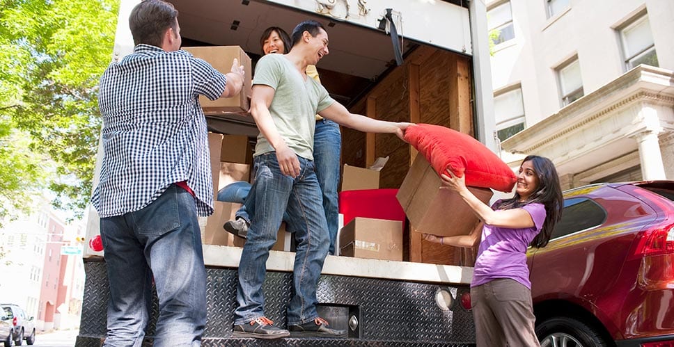 a group of young adults loading a moving truck