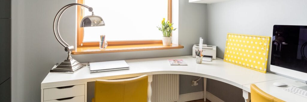 White wooden corner desk with office supplies