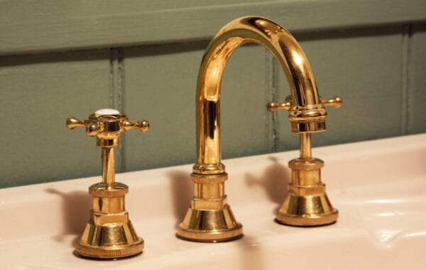 Close-Up Of Gold Tap And Faucet On Sink