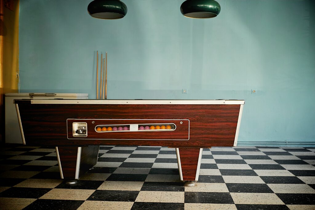 Vintage game room with pool table, with retro lamps and checkerboard floors