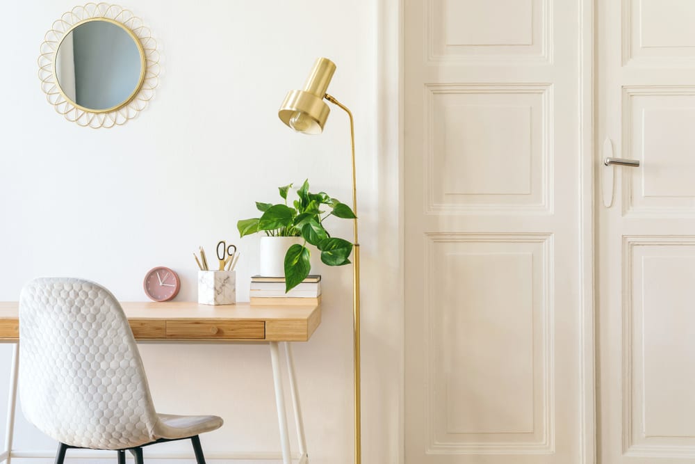 Bright home office with plant and gold accents