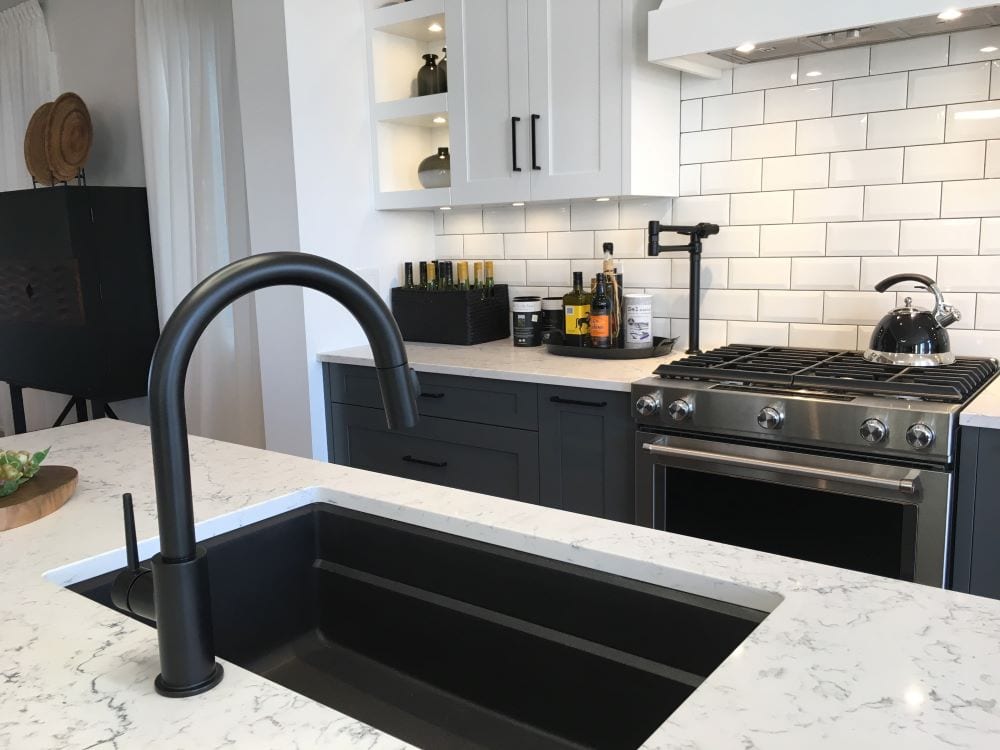 Modern kitchen sink, black sink against white countertop