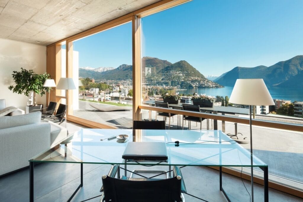 Modern home with floor to ceiling windows and view of the mountains