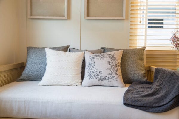 Beautiful pillows on beige fabric sofa in living room.