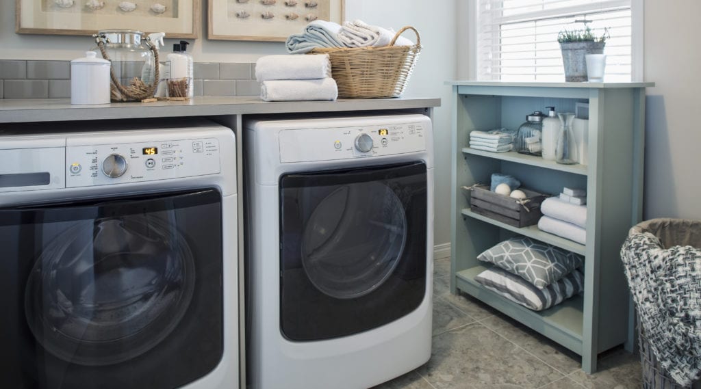 A brand new washer and dryer in a very organized laundry room.