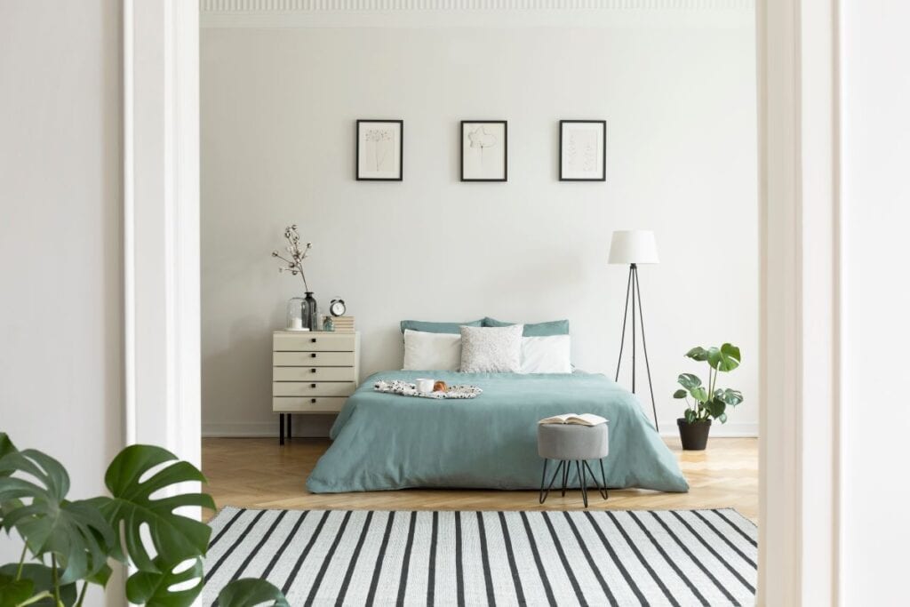 Bedroom with pastel comforter and striped area rug