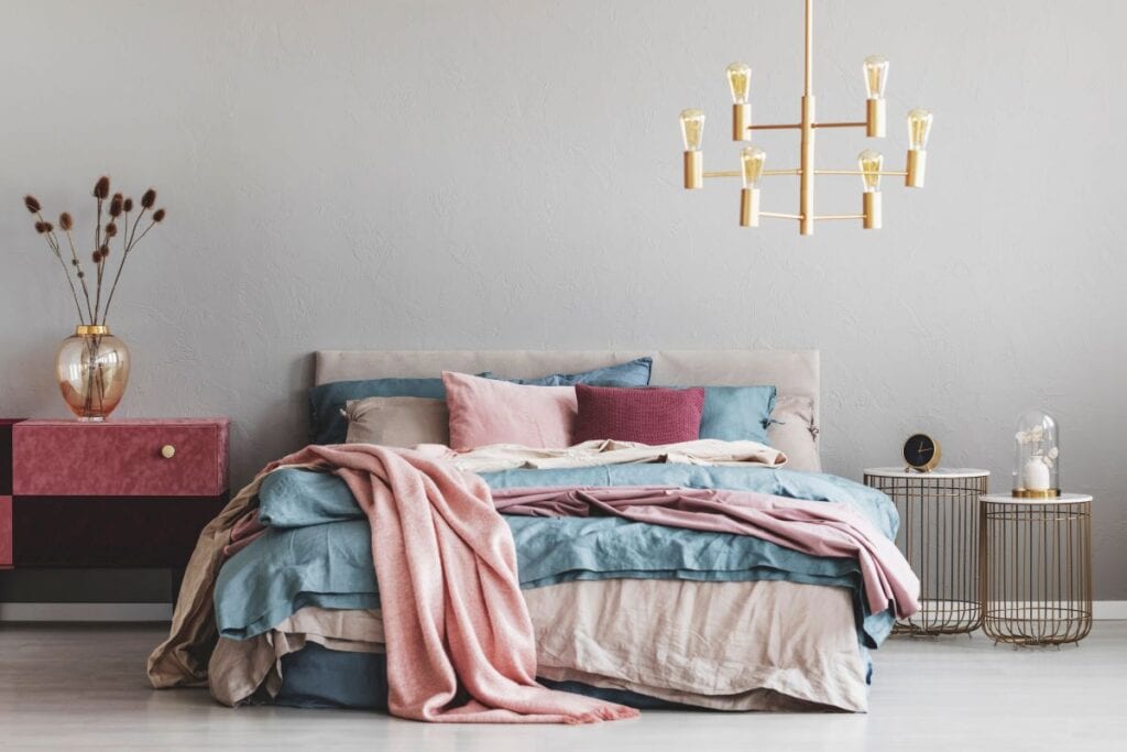 Bedroom with chandelier and blue, beige, and pink accents