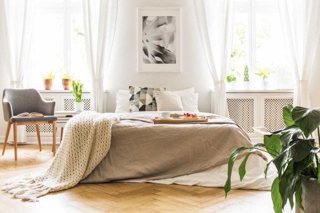 Bedroom with natural light from big windows and breezy curtains