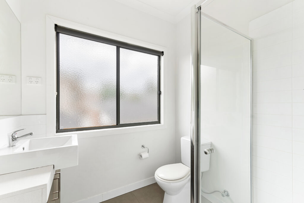 Textured windows allow for light and privacy in the bathroom.