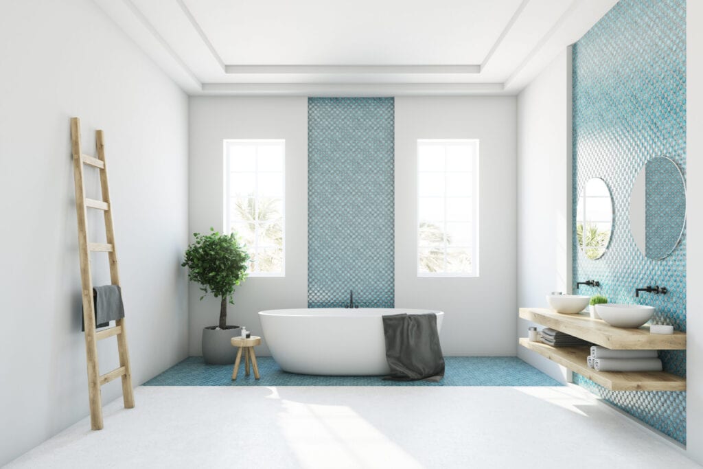 White and blue bathroom interior with a round white tub, two narrow windows, a tree in a pot and a ladder in a corner. Side view. 