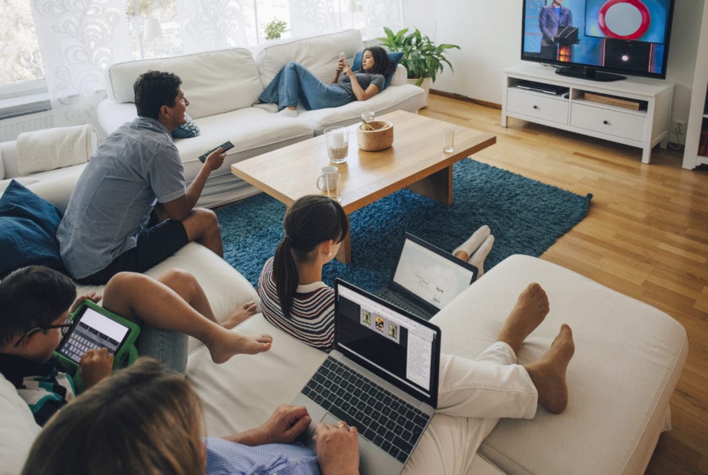 family on laptops and tablets watching tv