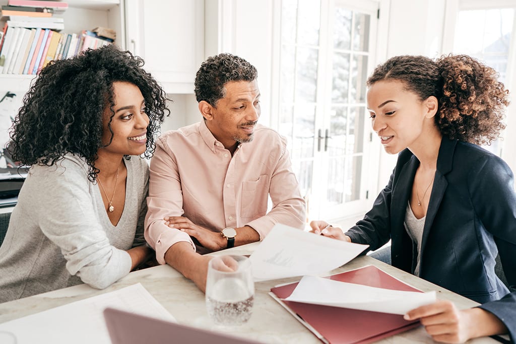 Three people looking over contract