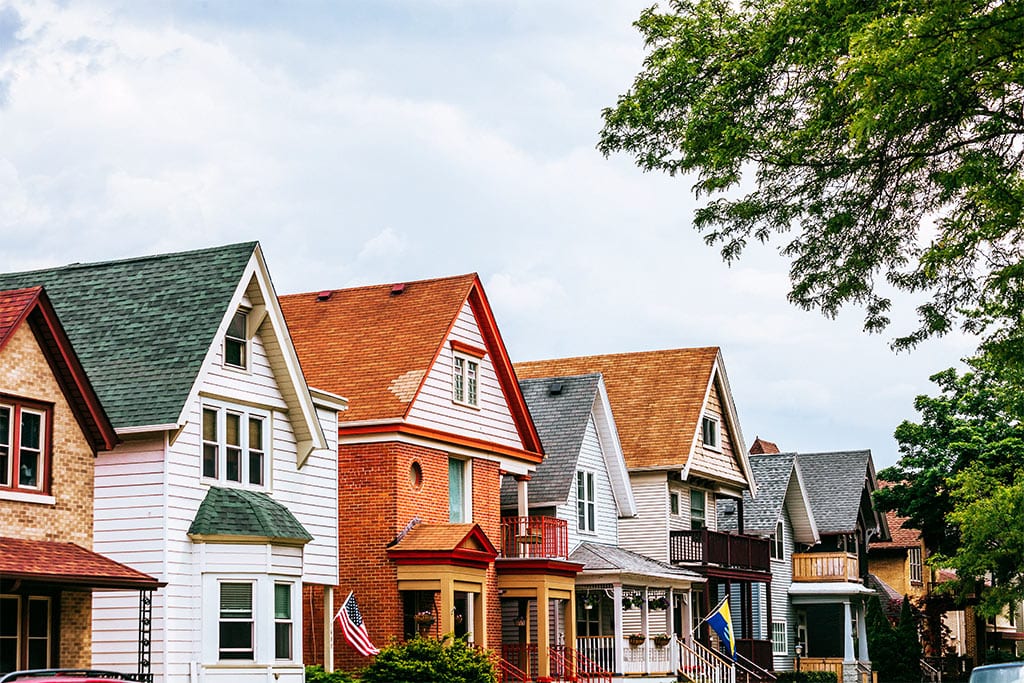 A colorful row of houses in what looks to be an appealing and safe neighborhood.