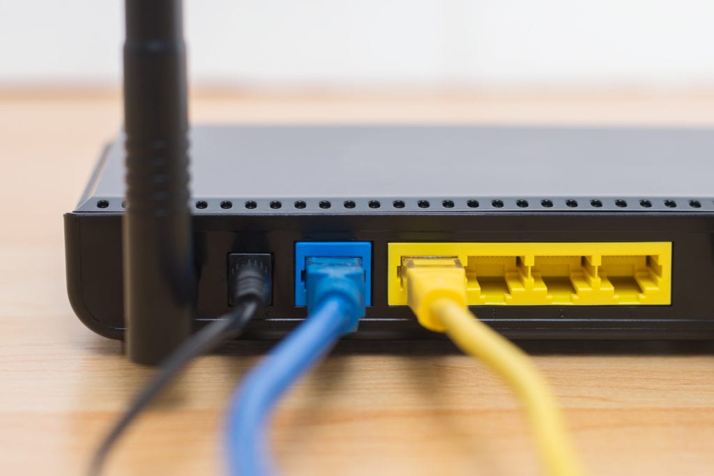 Close up of modem or router with black, blue, and yellow wires