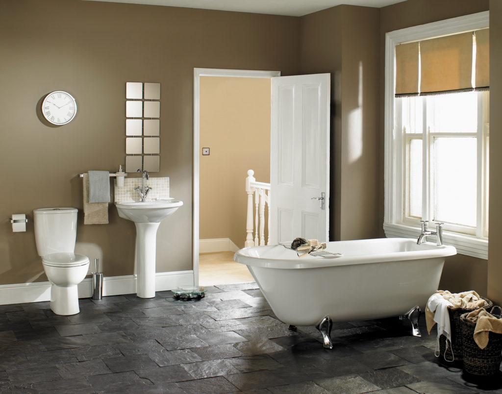 Bathroom with white tub and sink, and brown walls