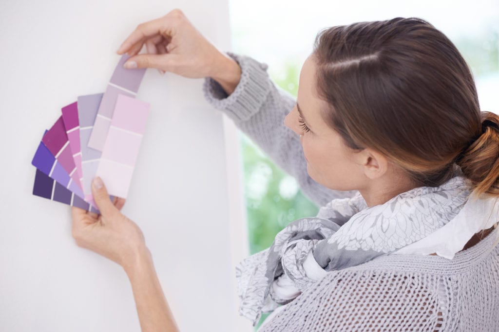 A young woman choosing the best color for her walls