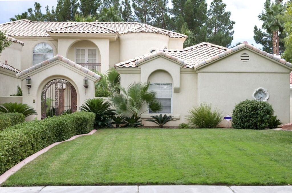 Front yard of upscale, ivory-colored home