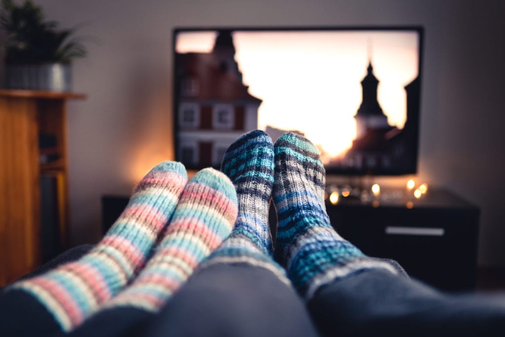 Two people watching tv at home and wearing cozy striped socks