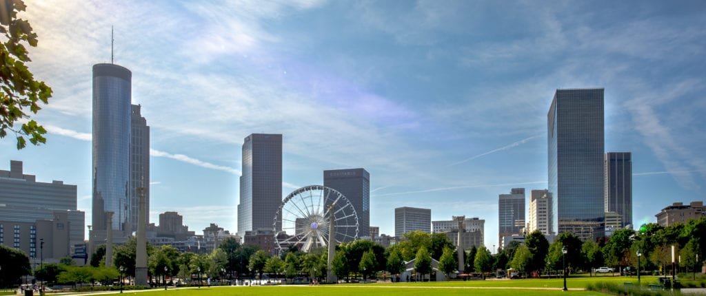 View of atlanta skyline from Centennial park, with buildings, trees, and ferris wheel