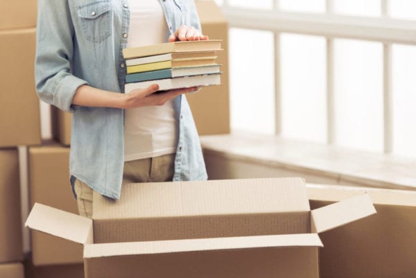 College woman packing box with books