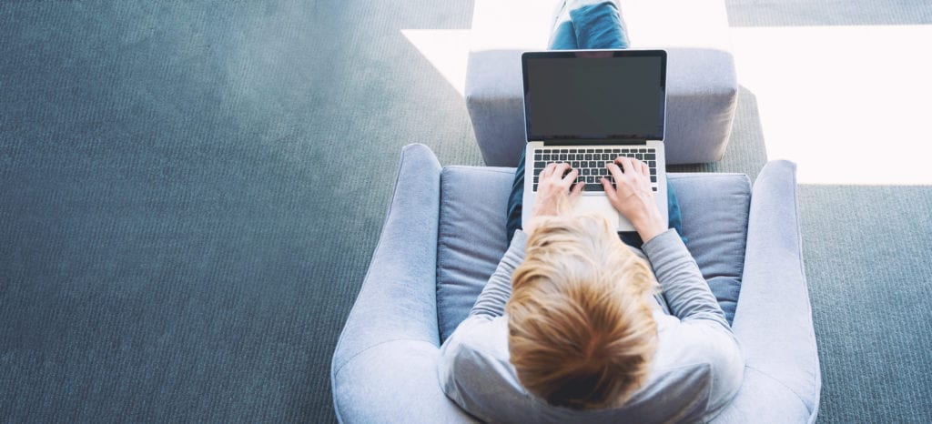 View of blonde man using laptop from overhead