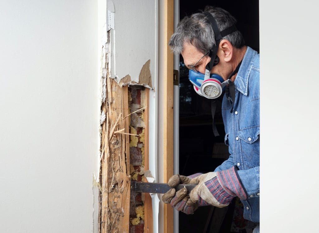 A man does a DIY termite treatment at home