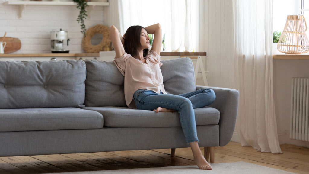 Woman relaxing comfortably in clean, modern home