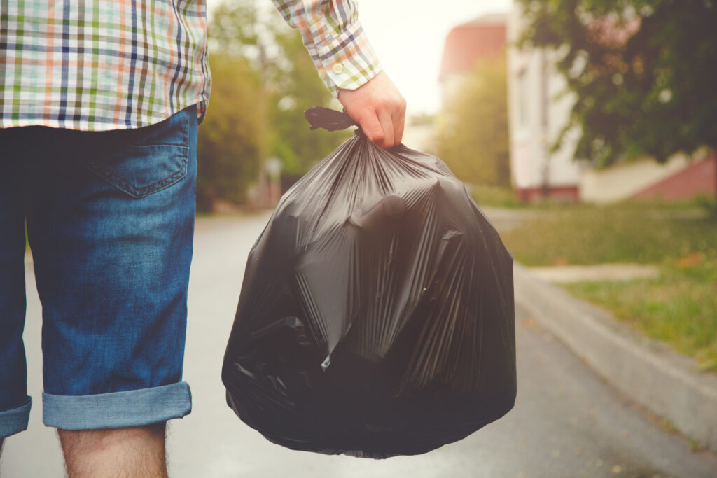 Man taking out the trash with maggots