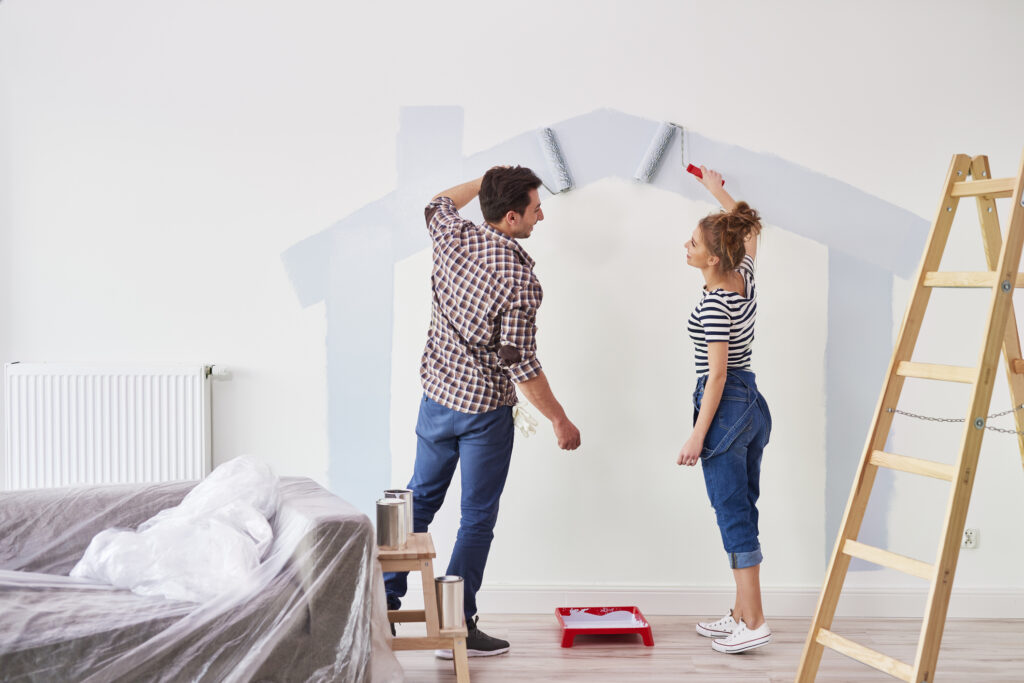 Couple painting wall at home