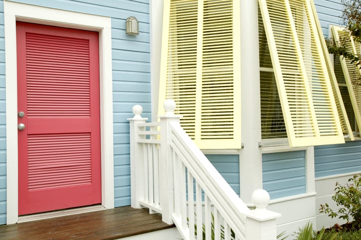 Yellow shutters, a coral door and blue wood siding