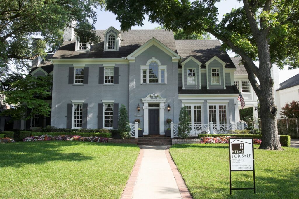 exterior shot of house with for sale sign in front yard